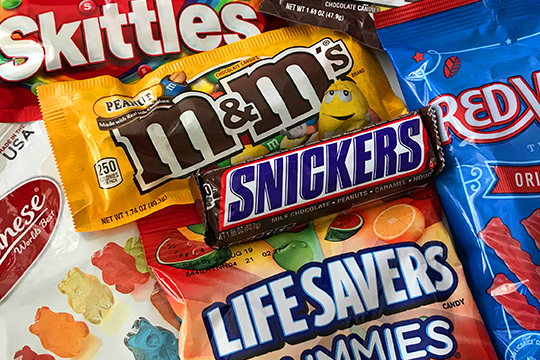 An assortment of candy including: M and M's, Skittles, Snickers, Life Savers Gummies, Albanese Gummy Bears, and Redvines.
