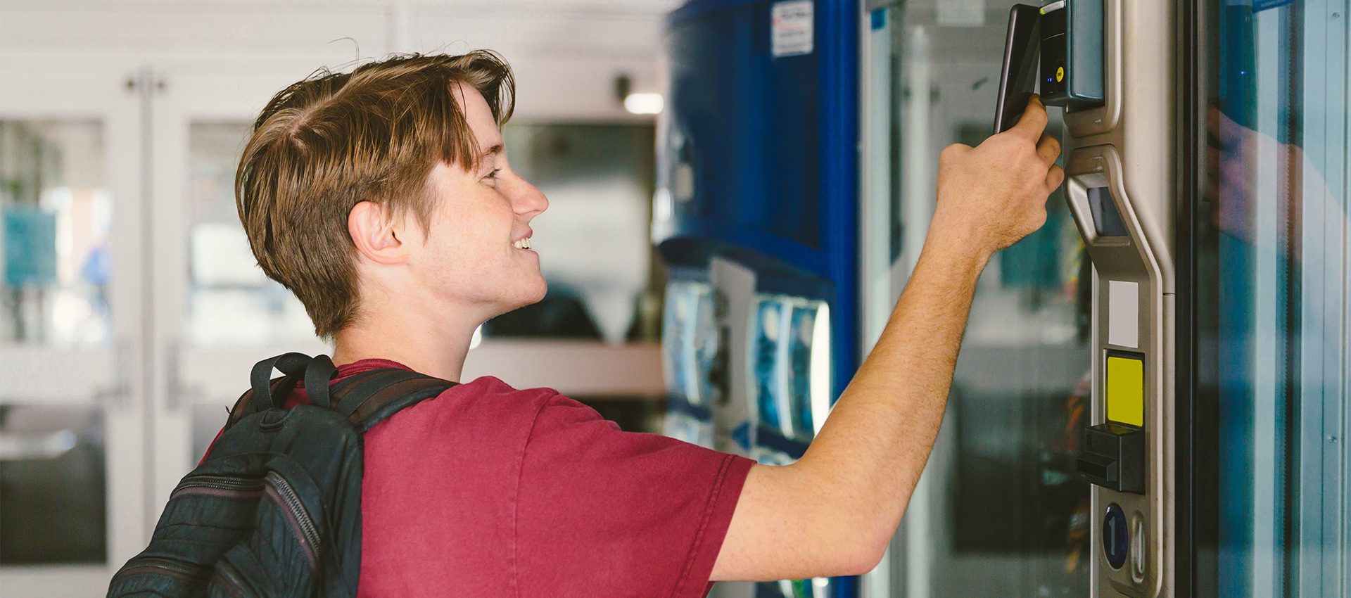 College student paying with his phone at a vending machine.